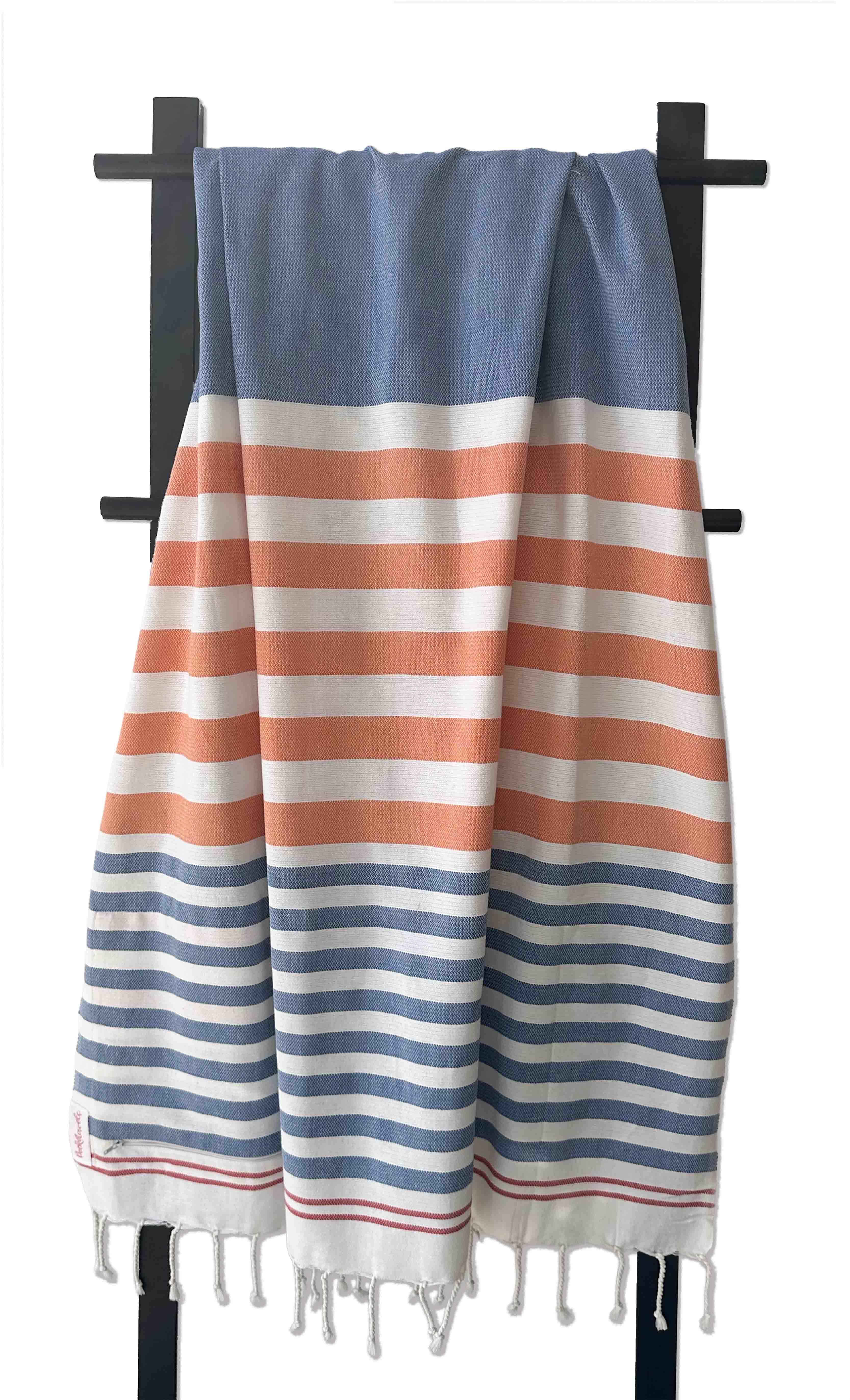 Striped towel with blue, orange, and white colors on a black rack. Pocketowels by Freostyle
