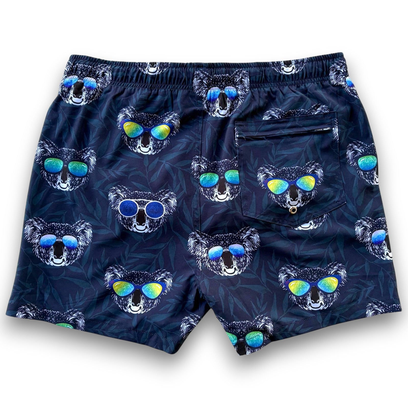 Navy swim shorts with koala pattern wearing sunglasses on a blue leafy background - South Beach Boardies made from recycled plastic bottles Kid Koala Men's Stretchy shorts- BACK VIEW