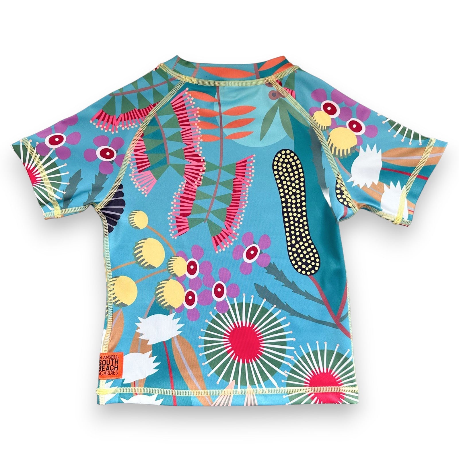 Colorful children's Rashie from recycled plastic bottles with a bird and floral design on a blue background, made by South Beach Boardies x Helen Ansell, back view