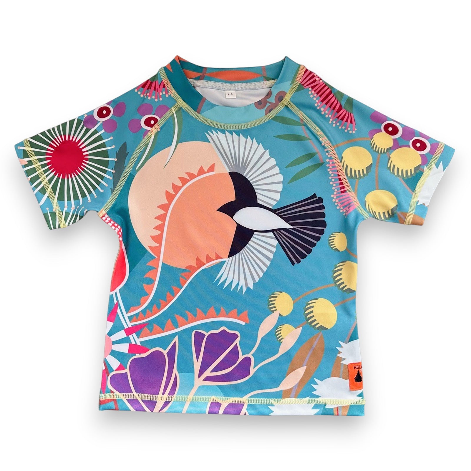 Colorful children's Rashie from recycled plastic bottles with a bird and floral design on a blue background, made by South Beach Boardies x Helen Ansell, front view