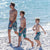 SouthBeachBoardies kids long boardies in Palm Springs print with matching mens version walking along beach