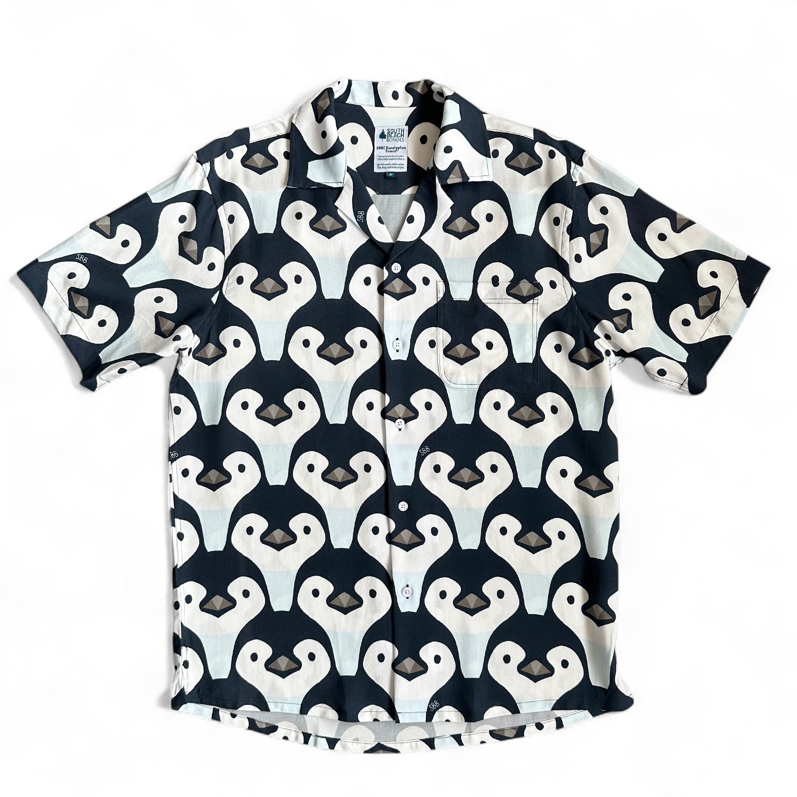 Short-sleeve shirt with penguin pattern on a white background, made by South Boardies