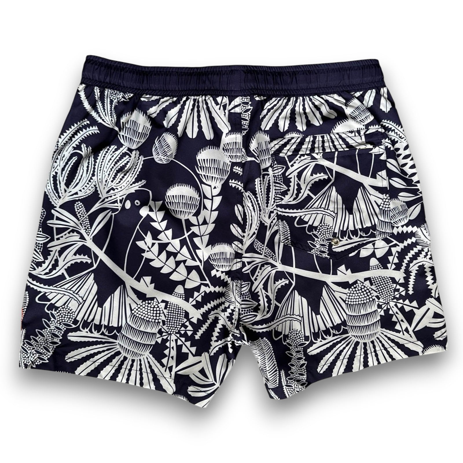 Navy swim shorts with pale sage green Banksia pattern and orange drawstring , made from recycled plastic bottles by South Beach Boardies x Helen Ansell, back view