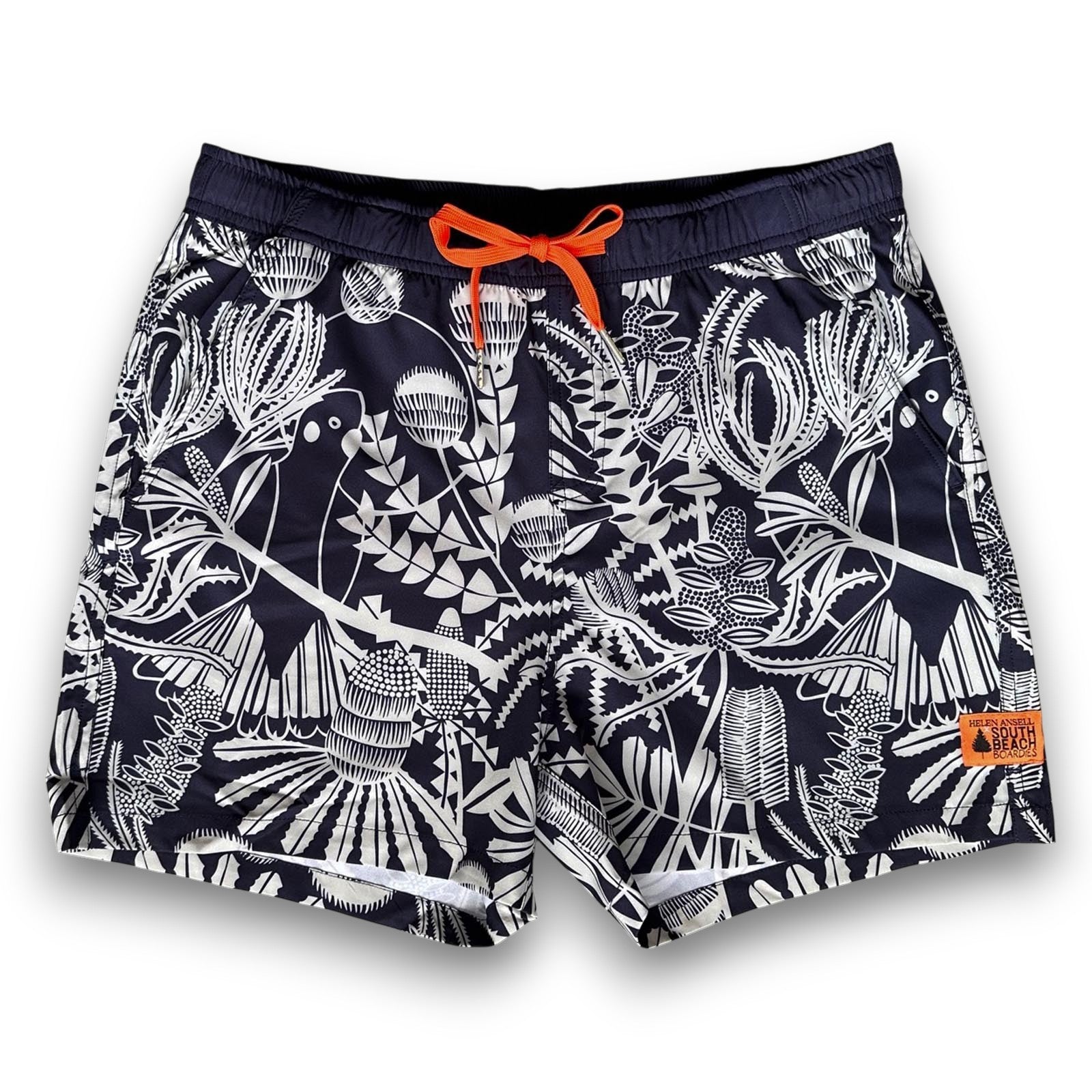 Navy swim shorts with pale sage green Banksia pattern and orange drawstring , made from recycled plastic bottles by South Beach Boardies x Helen Ansell, front view
