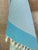 Freostyle Turkish Beach Towel with Pockets, Capri, Aqua Blue, hung on wall