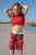 Girl wearing South Beach Boadies from recycled plastic. Kids Long Boardies in Plesiosaurs, front view